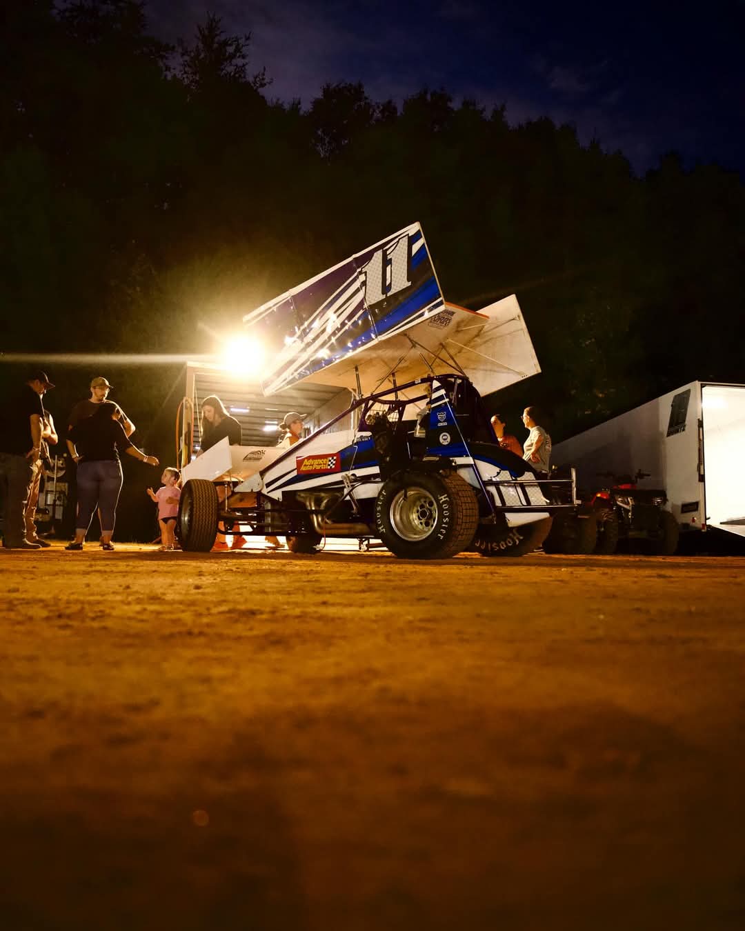 Sprint car under stadium lights in pit area
